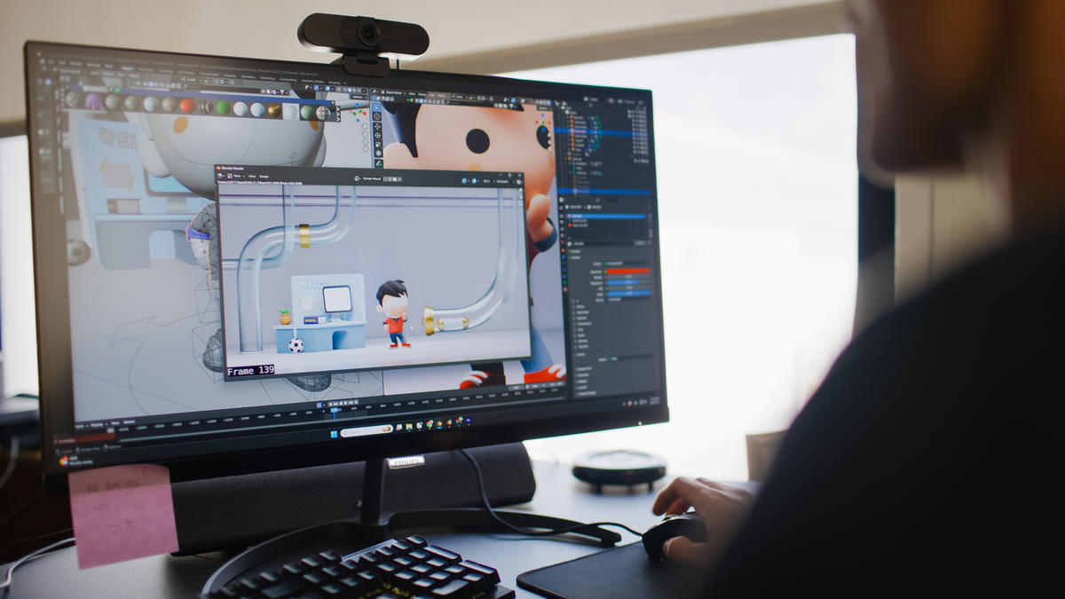 A person on a computer designing a tiny saint cartoon