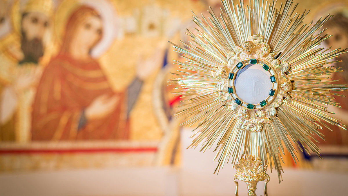 Rome, Italy – June 2015 – Adoration monstrance with the Blessed Sacrament on the altar, artistic edit with dark vignette and copy space for text