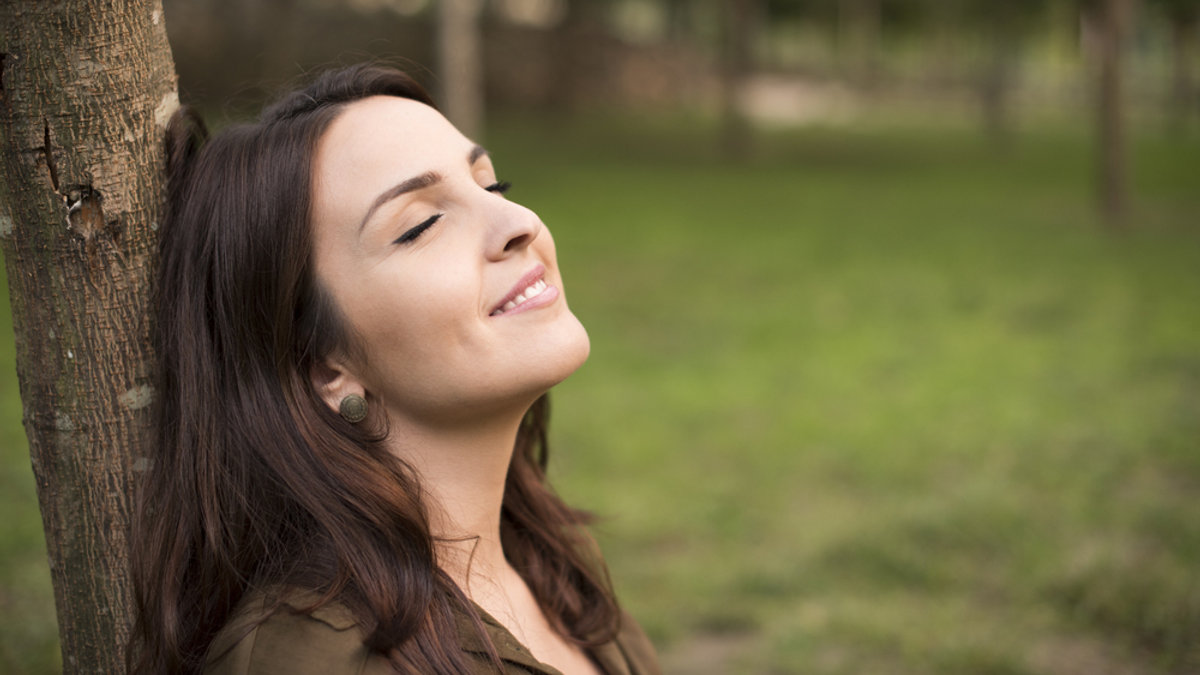 Mujer sonriendo con paz interior. Sentimientos