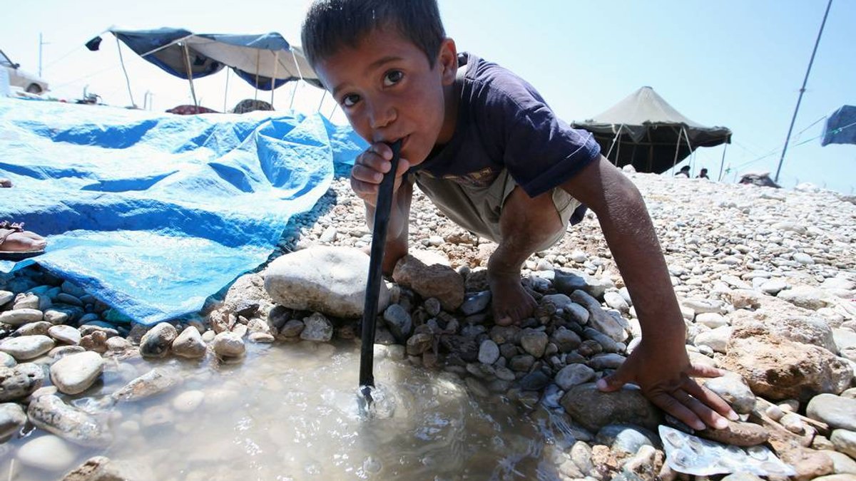 web-refugee-boy-playing-water-huseyin-ozddemir1-shutterstock
