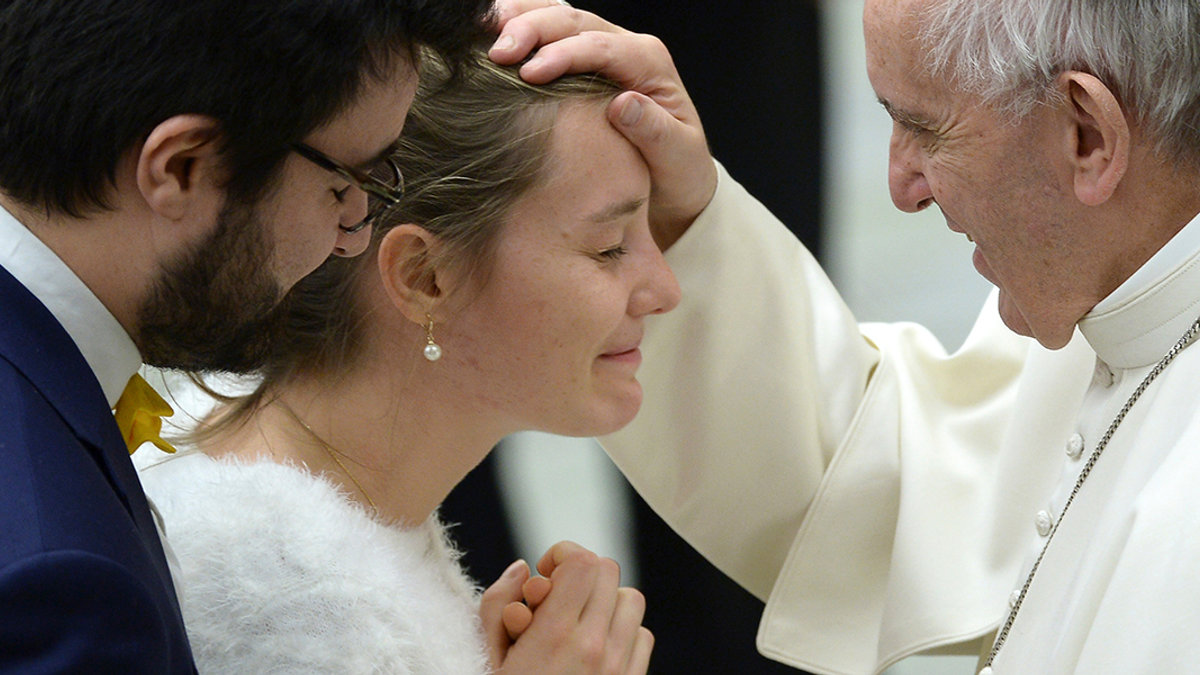 A newly wedded couple with Pope Francis