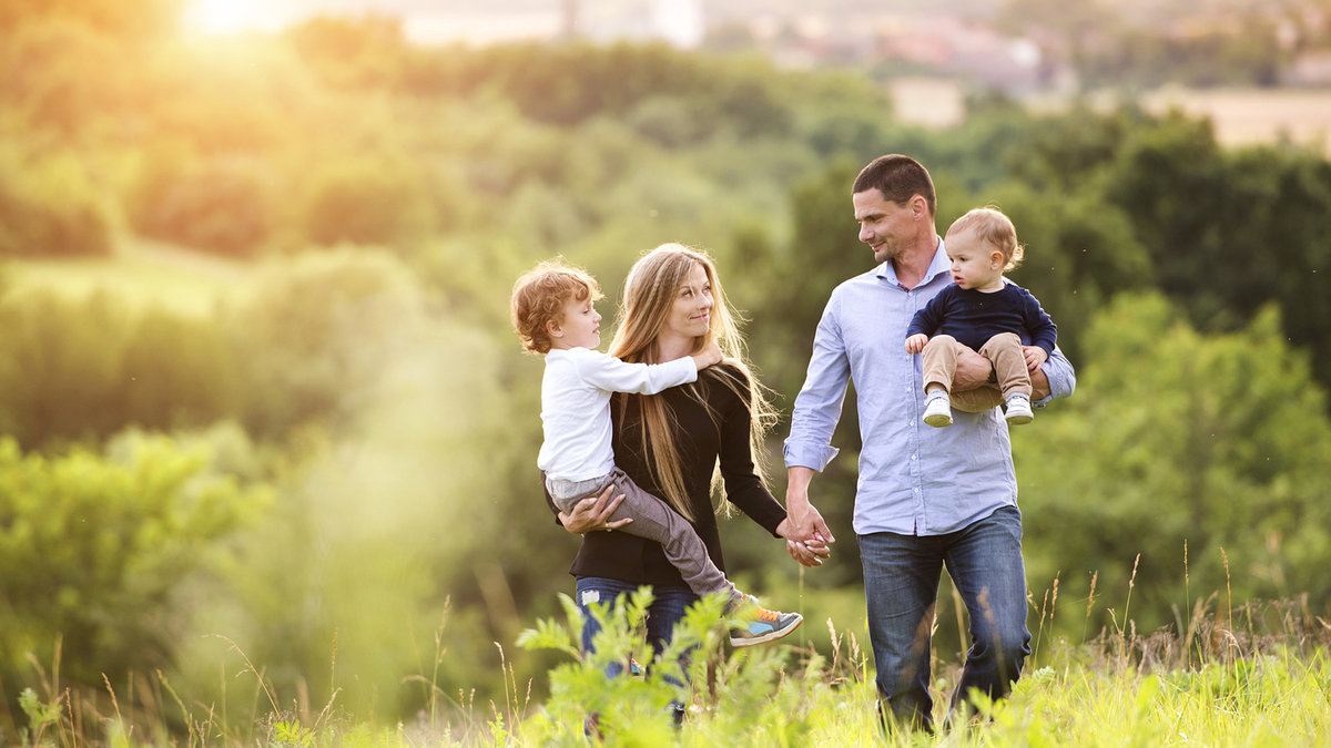 WEB Happy young family spending time together outside in green nature