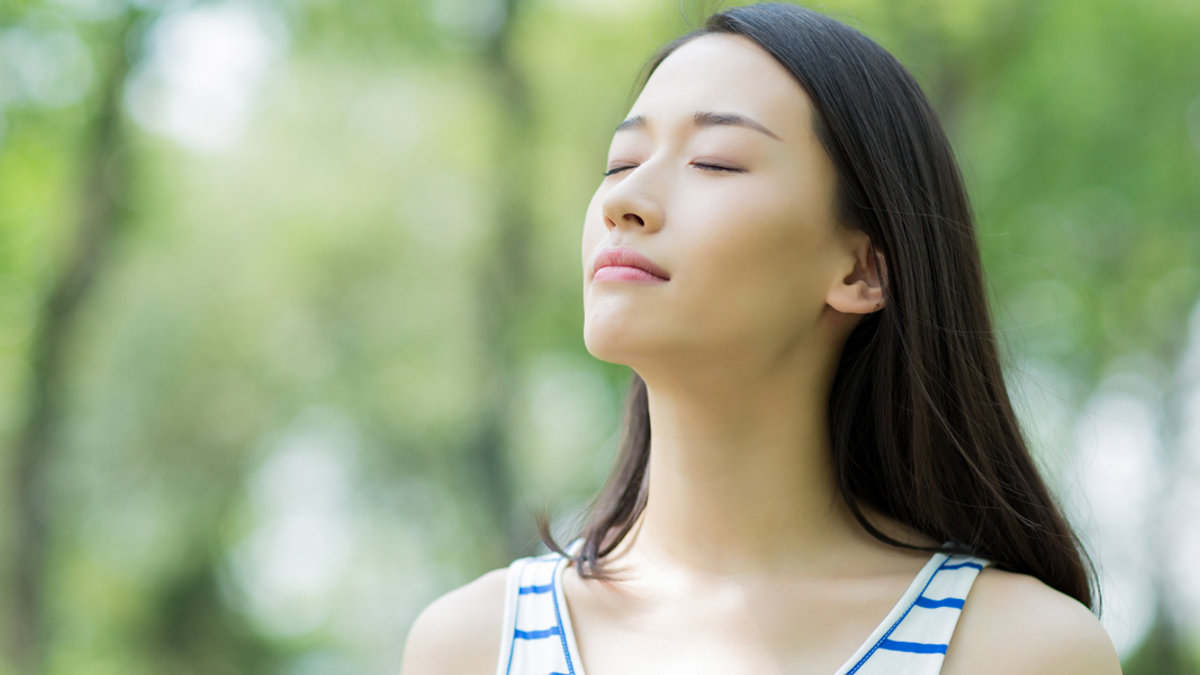 WEB3 ASIAN WOMAN DEEP BREATHS OUTSIDE BREATHING Shutterstock