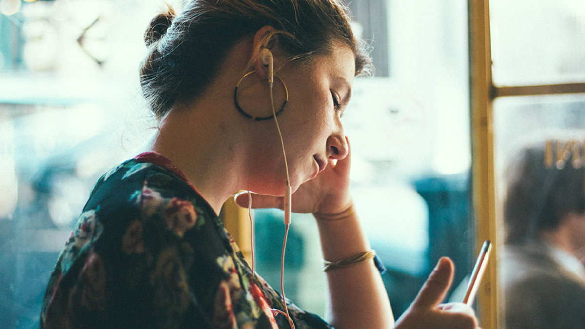 WEB3-WOMAN-HEADPHONES-MOODY-PENCIL-WRITING-LISTENING-Siddharth-Bhogra-Unsplash