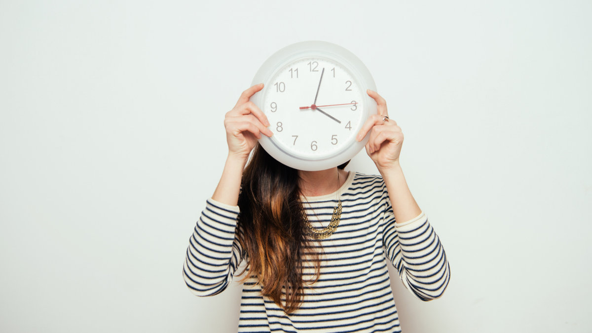 FEMME QUI TIENT UNE HORLOGE