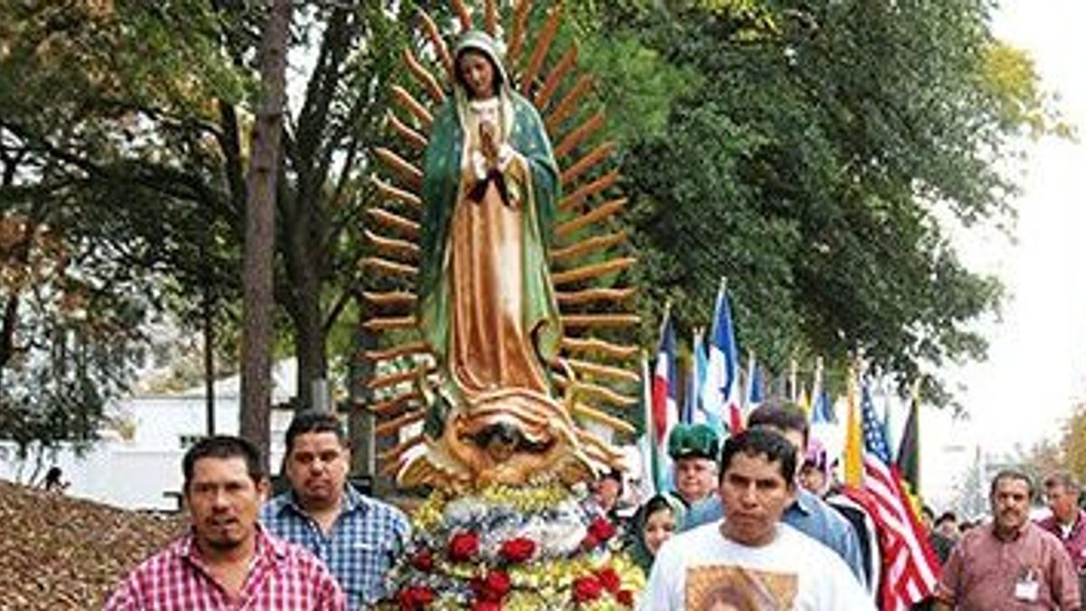 Members of the Cathedral of St. Peter the Apostle process with the statue of the
