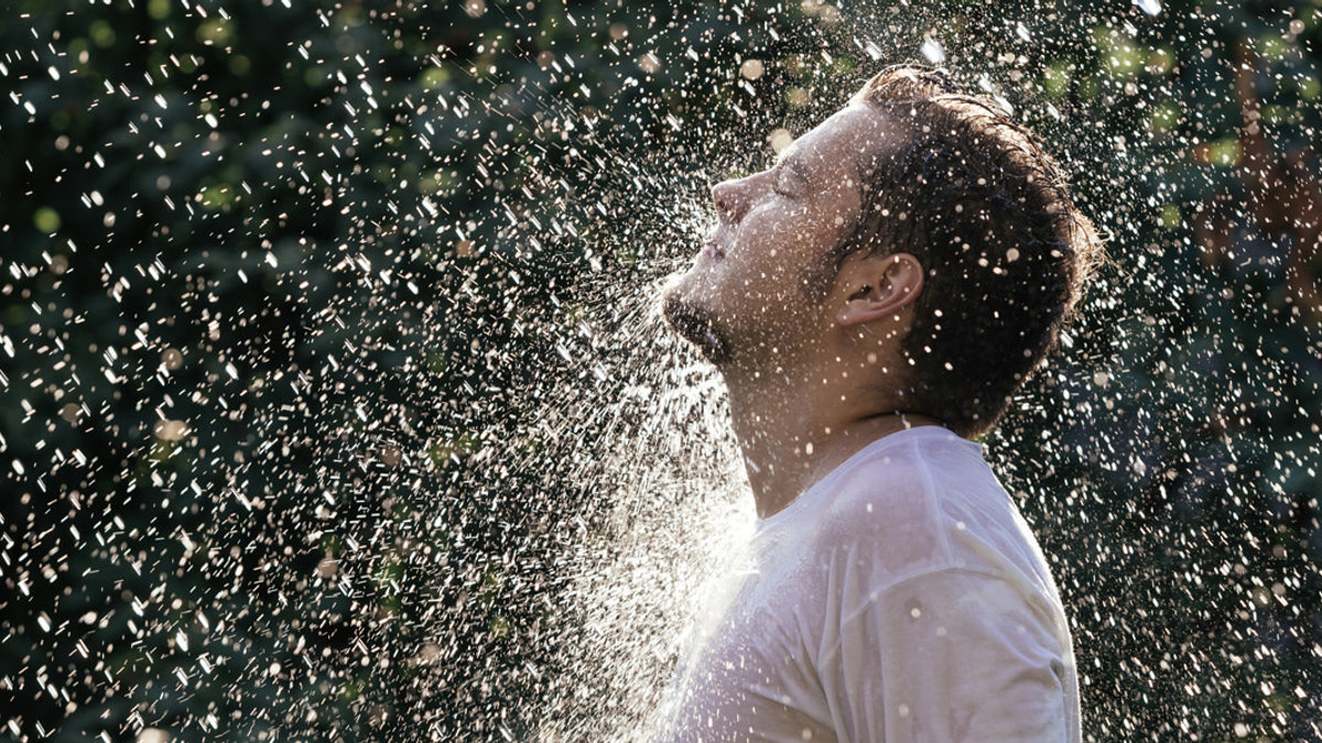 web3-young-handsome-man-in-white-t-shirt-having-shower-in-the-sunny-rain-at-the-summer-garden-shutterstock_307415330