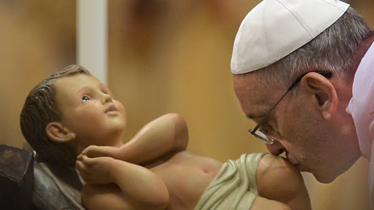 Pope Francis kisses the unveiled baby Jesus during a Christmas Eve mass at St Peter’s Basilica – pt