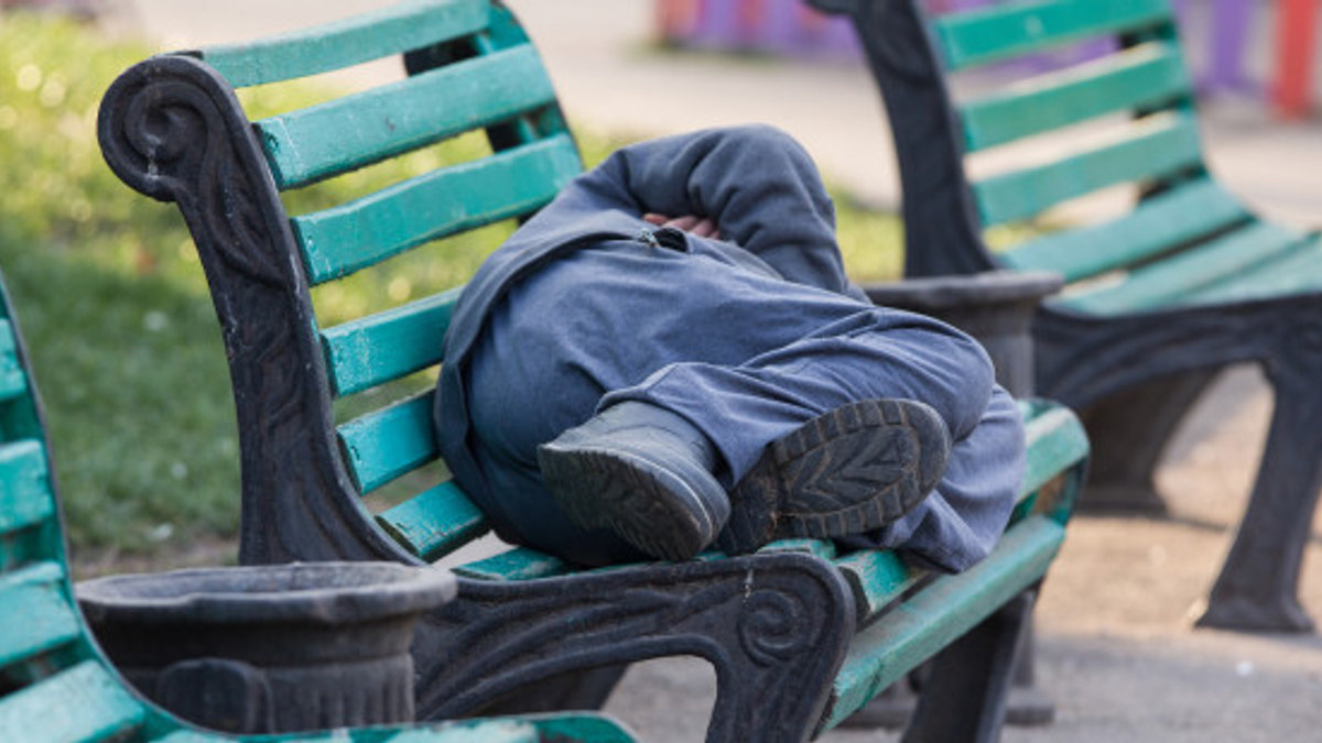 MAN SLEEPING ON BENCH