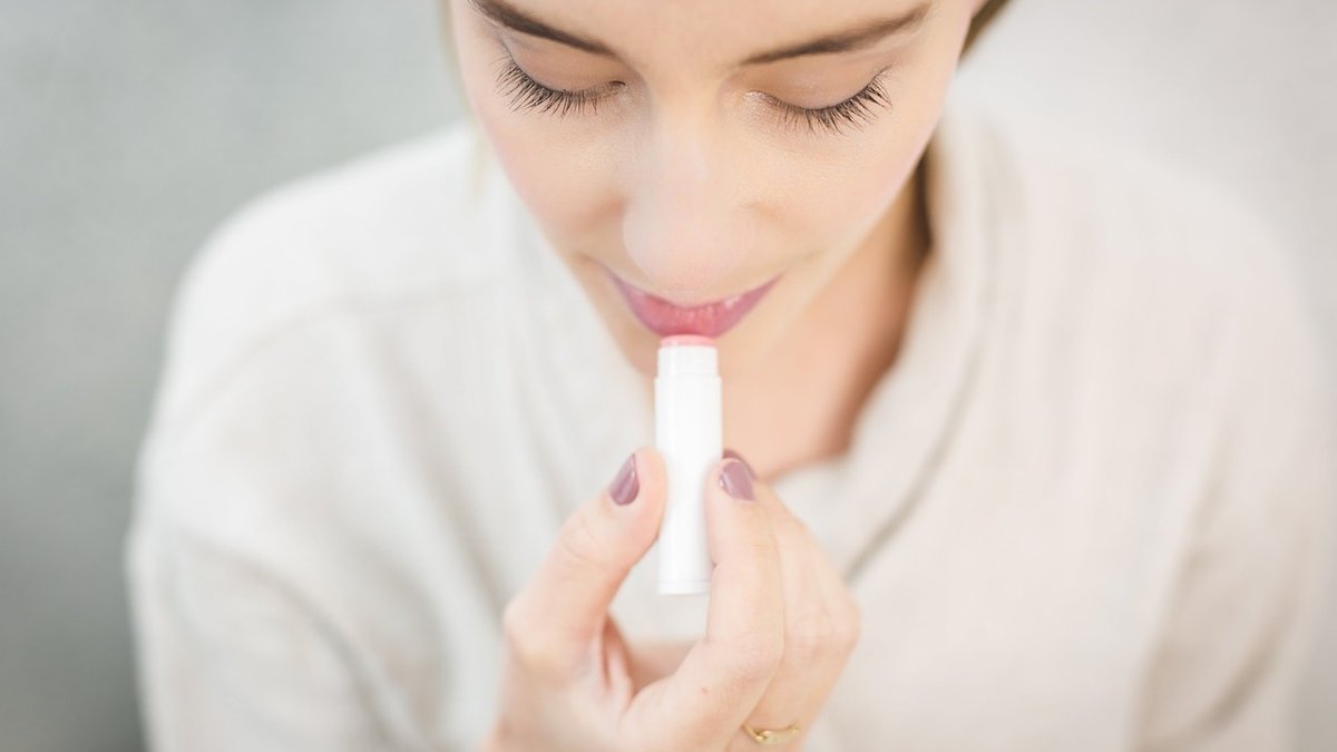 Woman using lipstick