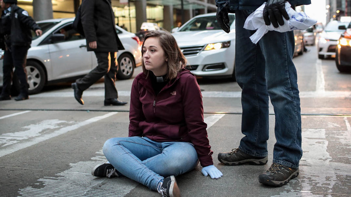 WOMAN SITTING IN THE MIDDLE OFTHE STREET