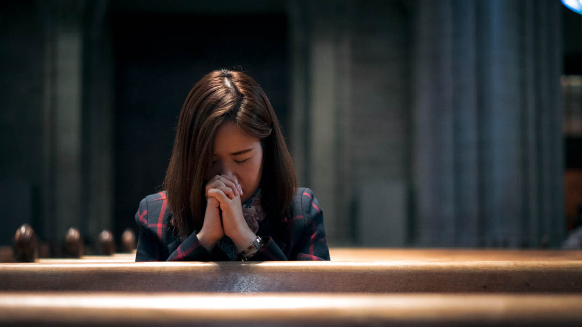WOMAN PRAYING,CHURCH PEWS