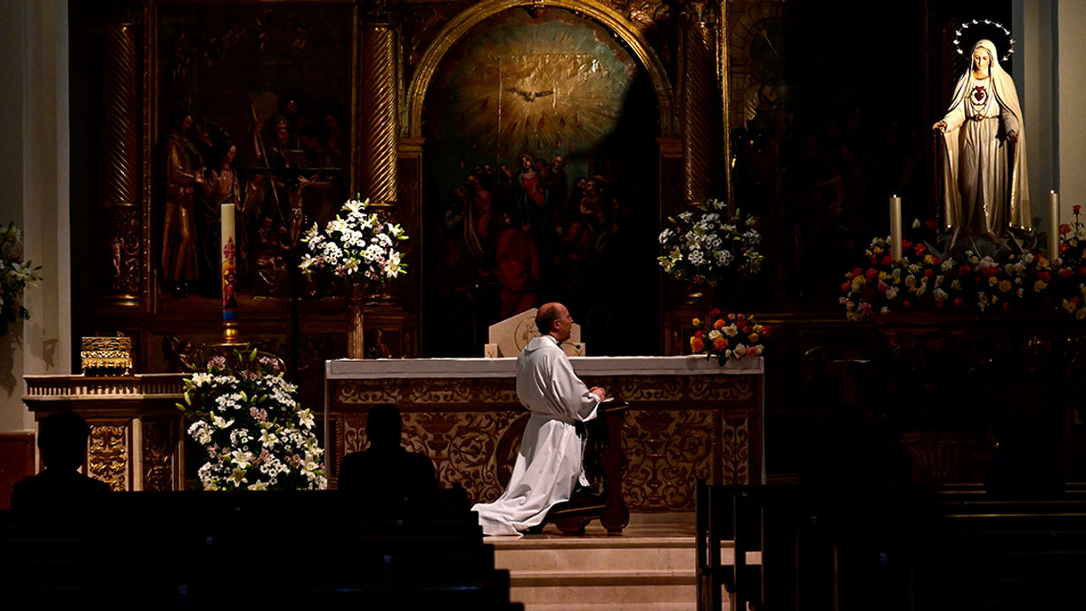 PADRE REZANDO NA IGREJA