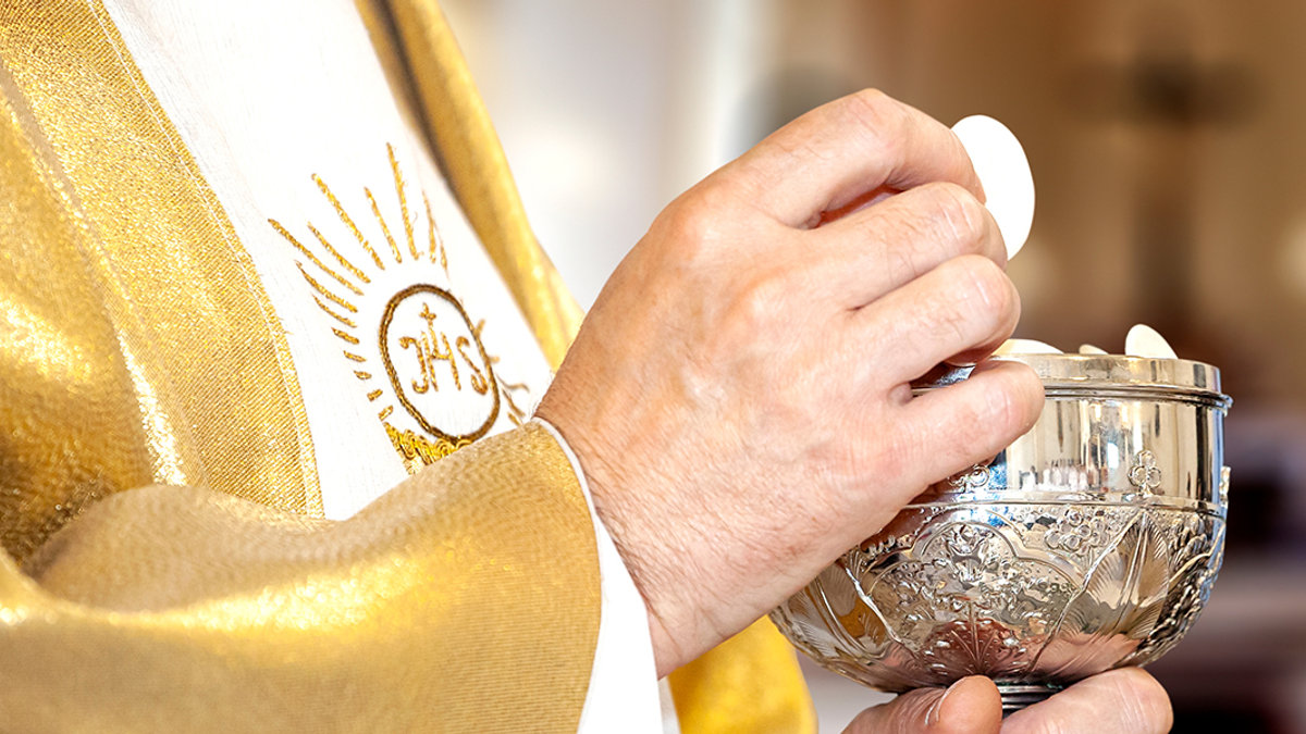 Eucaristia: um padre e a comunhão