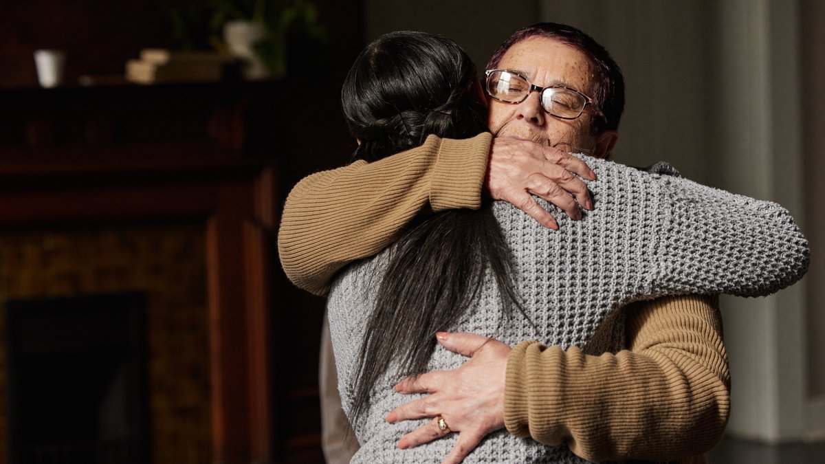older woman hugging younger woman