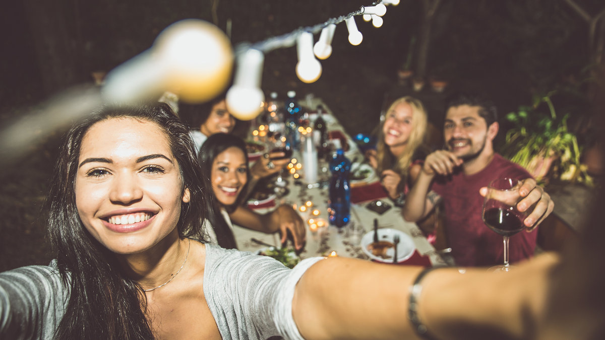 Group-of-friends-making-barbecue-in-the-backyard-at-dinner-time-shutterstock