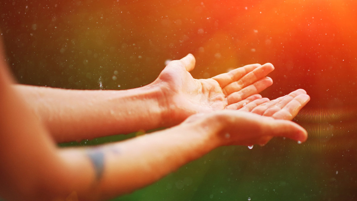 Womans hand catch rain drops