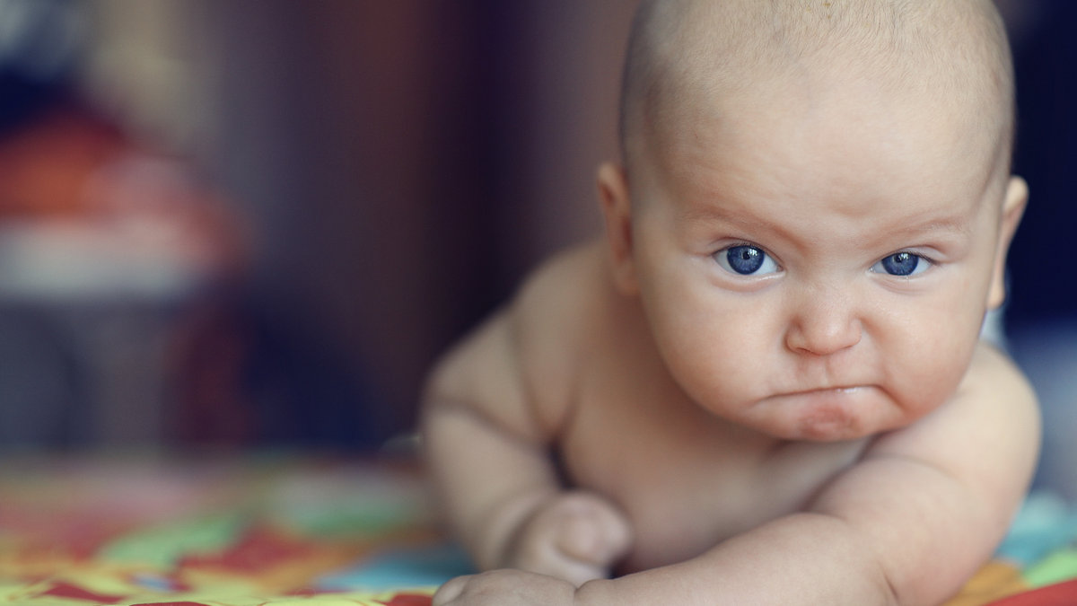 baby pounding table with stern face