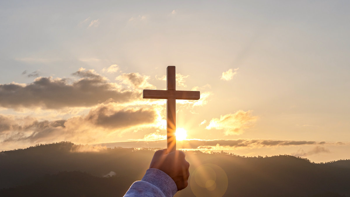 Christian Christianity Religion copy space background Human praying and holding christian cross for worshipping God at sunset background silhouette