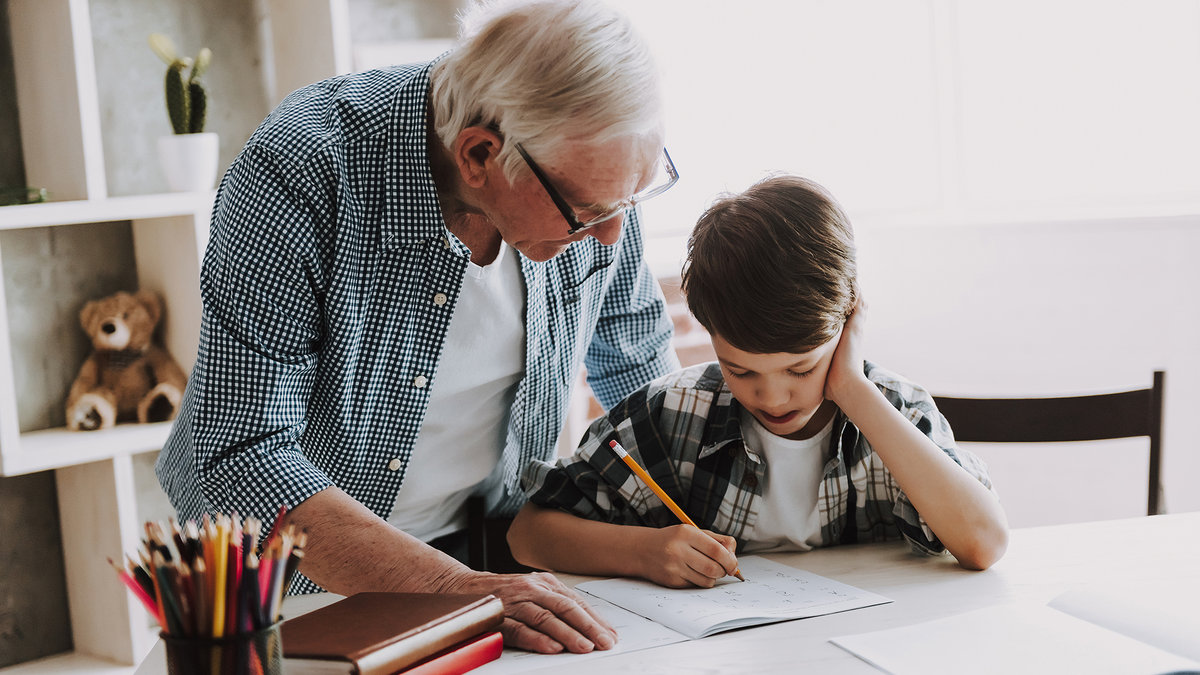 Grandson-Doing-School-Homework-with-Old-Man-Home.-shutterstock