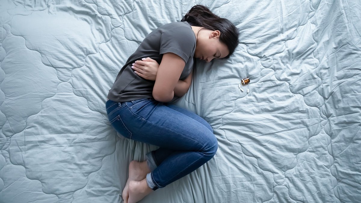 mulher com dor representa riscos de pílulas abortivas indiscriminadas