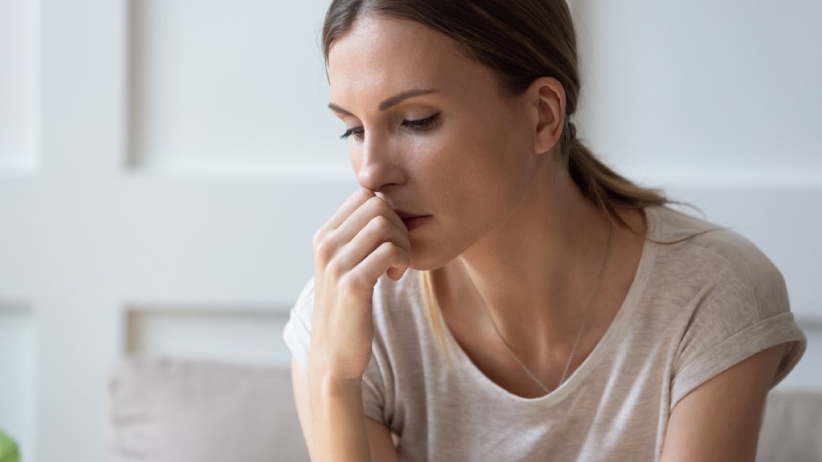 Close up of sad pensive millennial woman sit alone