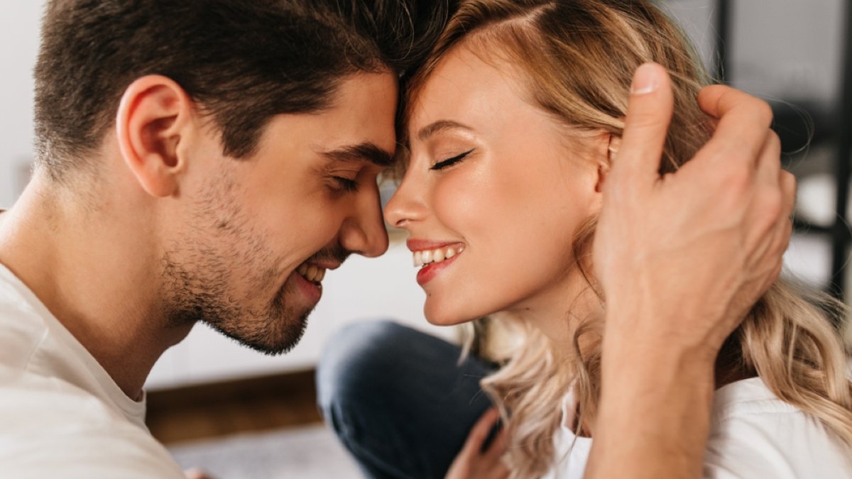 Portrait of two beautiful people in love smiling with closed eyes