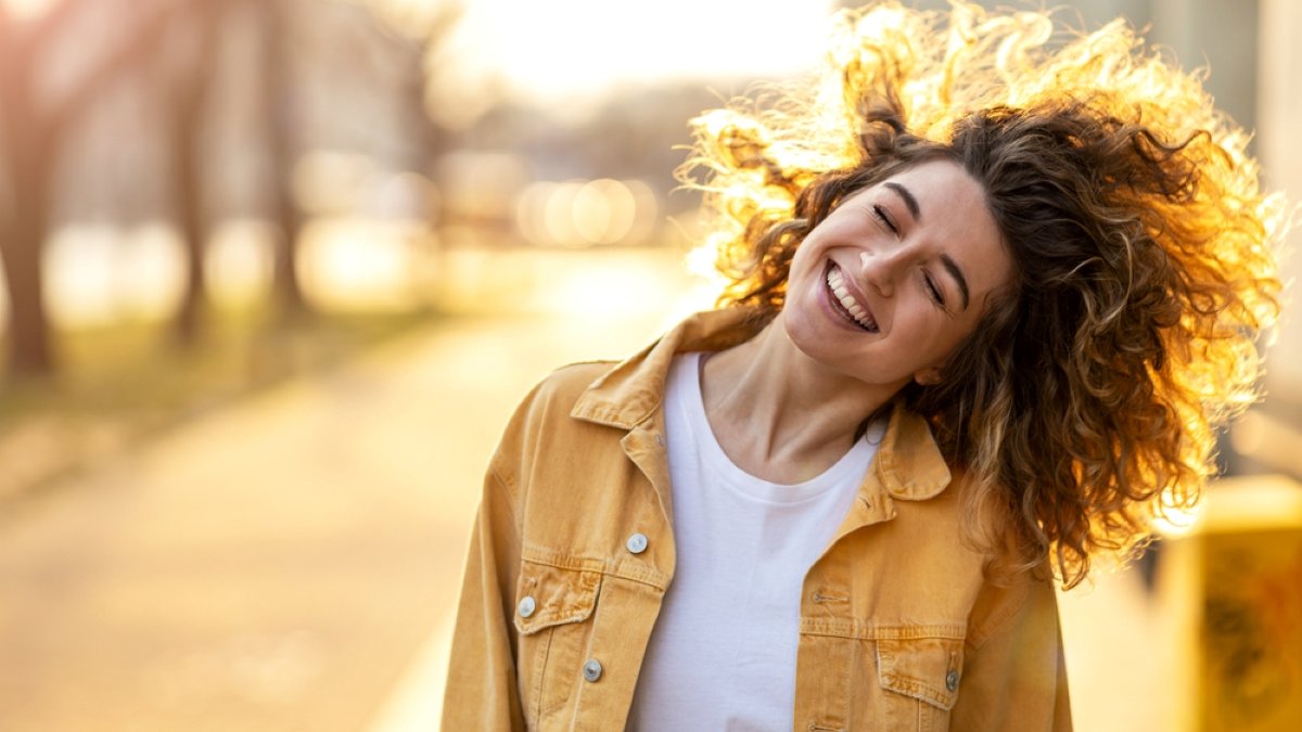 Portrait of young woman with curly hair in the city