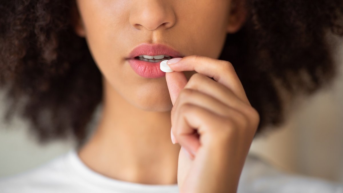 woman hesitates to take pill