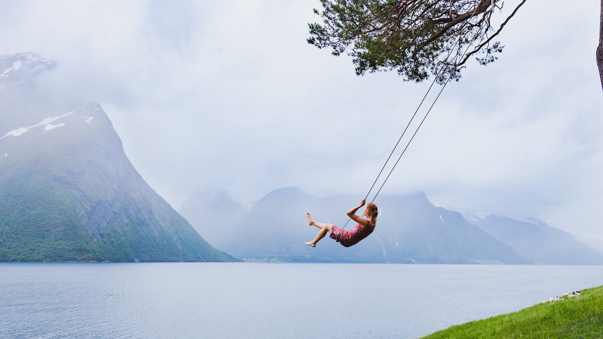woman swinging ocean mountain mist beauty