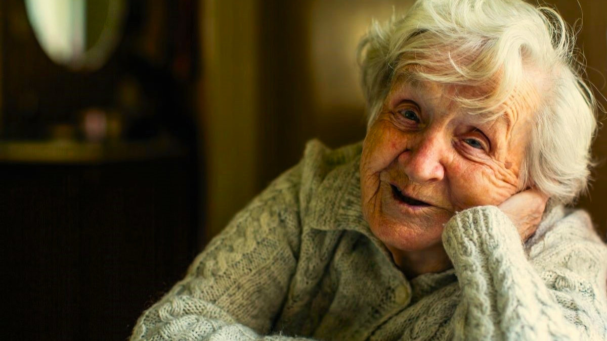 Old Irish woman leaning on window sill