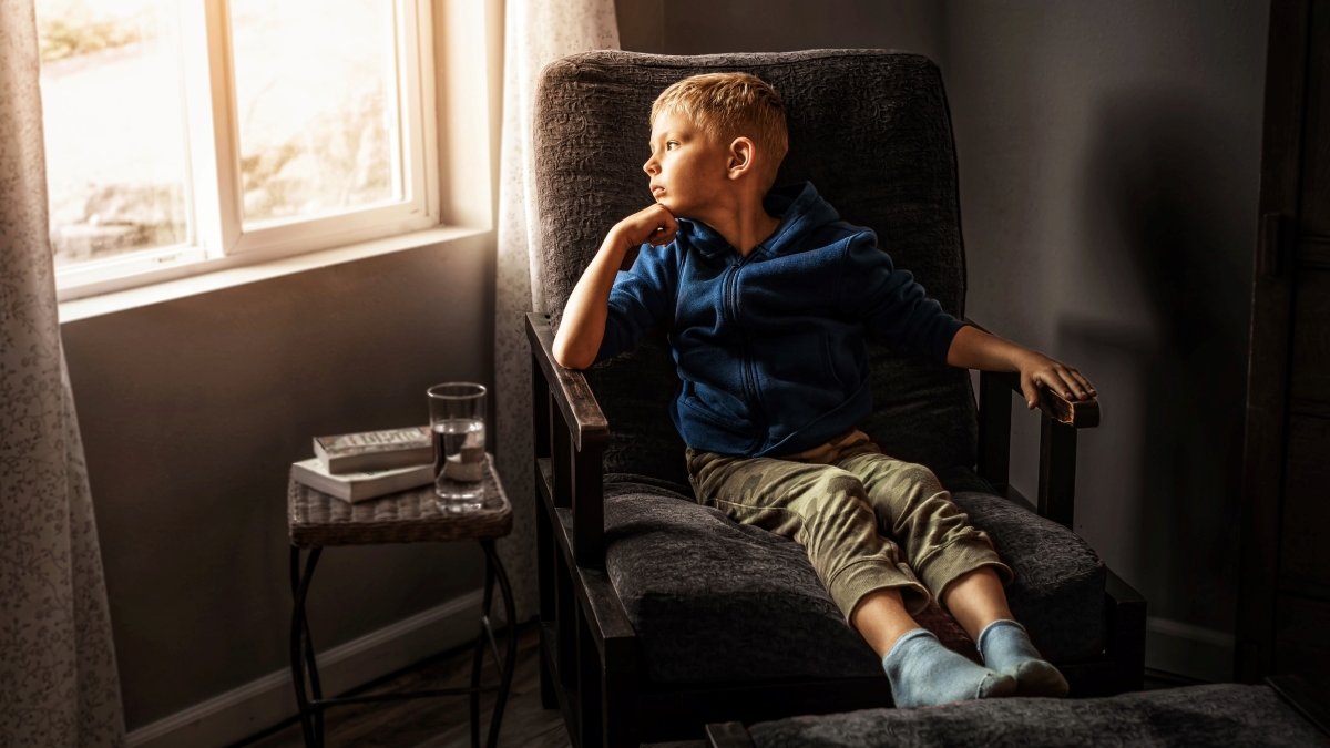 Thoughtful boy looking out window