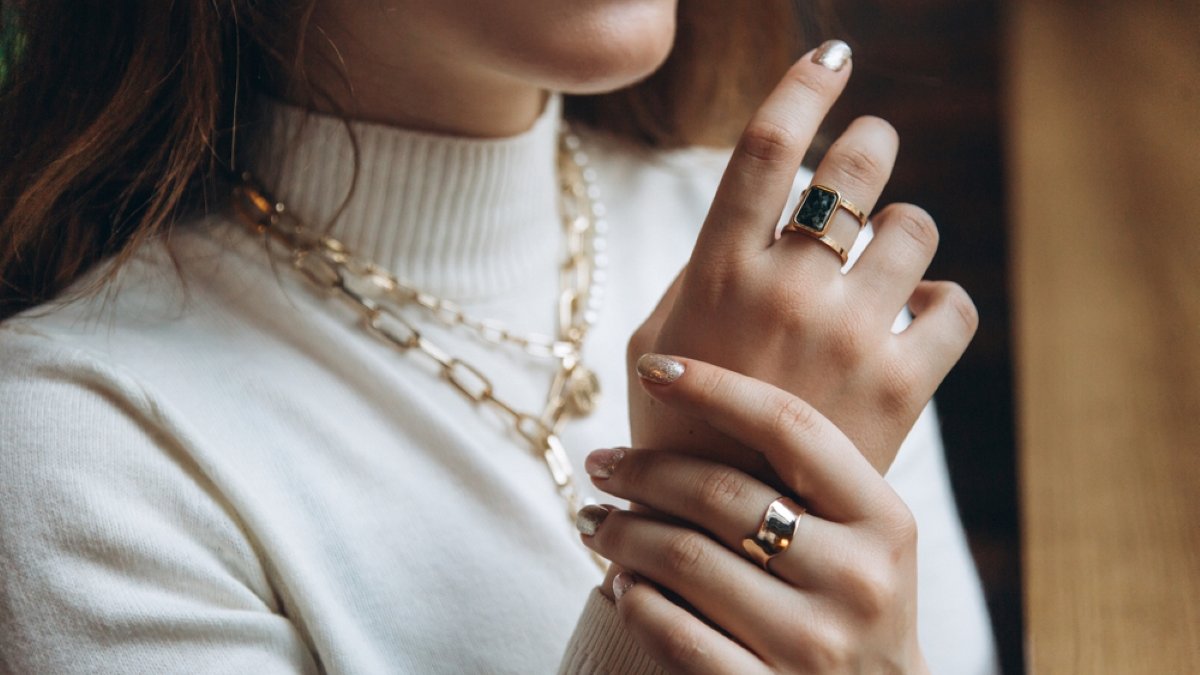 Woman's hands close up wearing rings and necklace