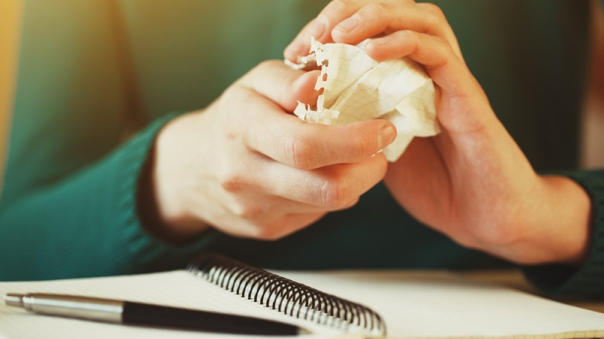 hands wresting the sheet of paper and making paper ball after mistake during writing