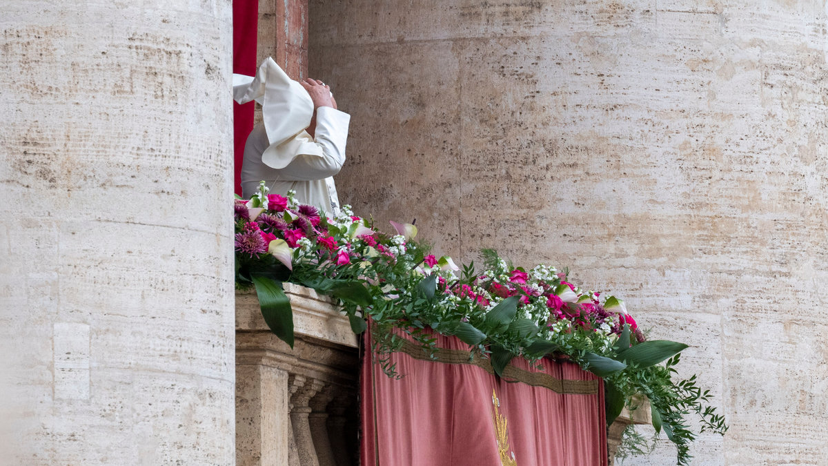 Pope Francis waves from the central loggia of St. Peter's basilica during the Easter 'Urbi et Orbi' message and blessing to the City and the World as part of the Holy Week celebrations