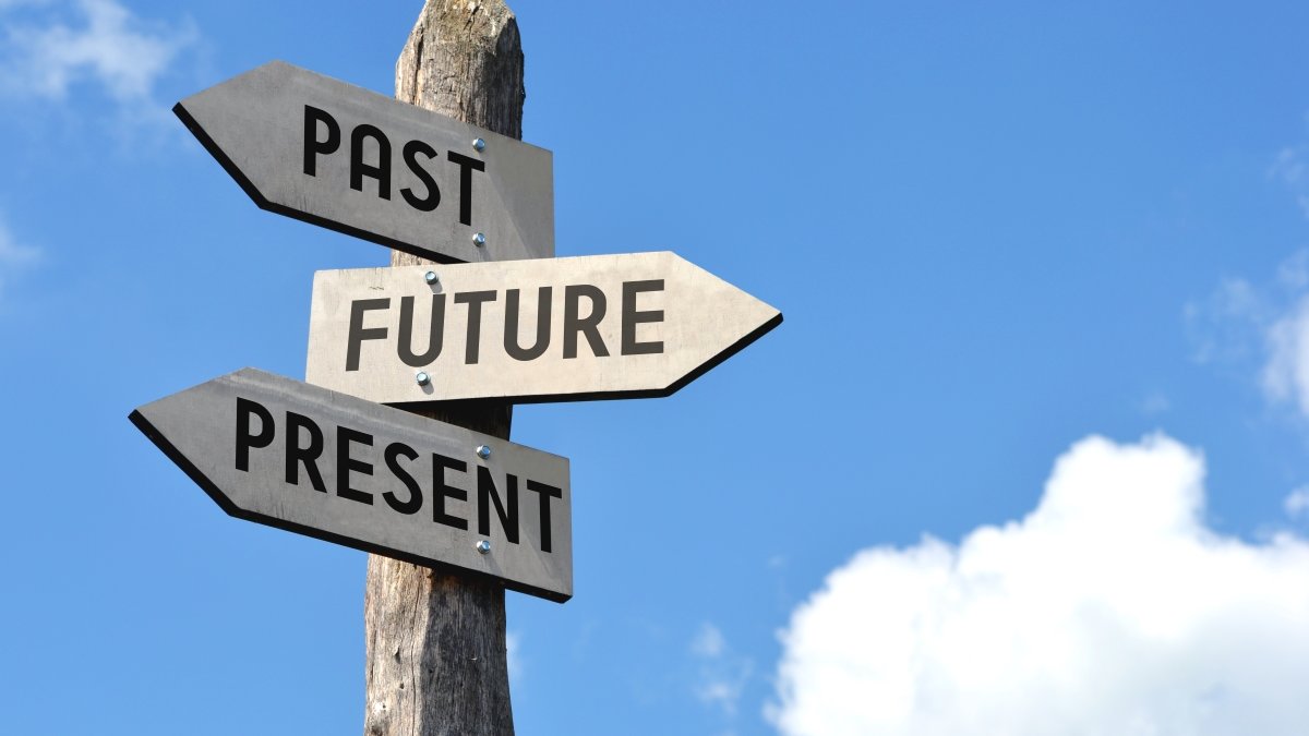 "Past, future, present" - wooden signpost, cloudy sky