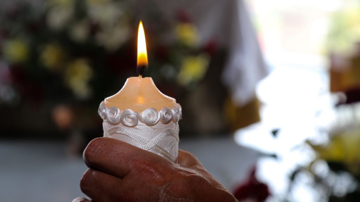paschal-candle-in-adult-hand-shutterstock_1384116209