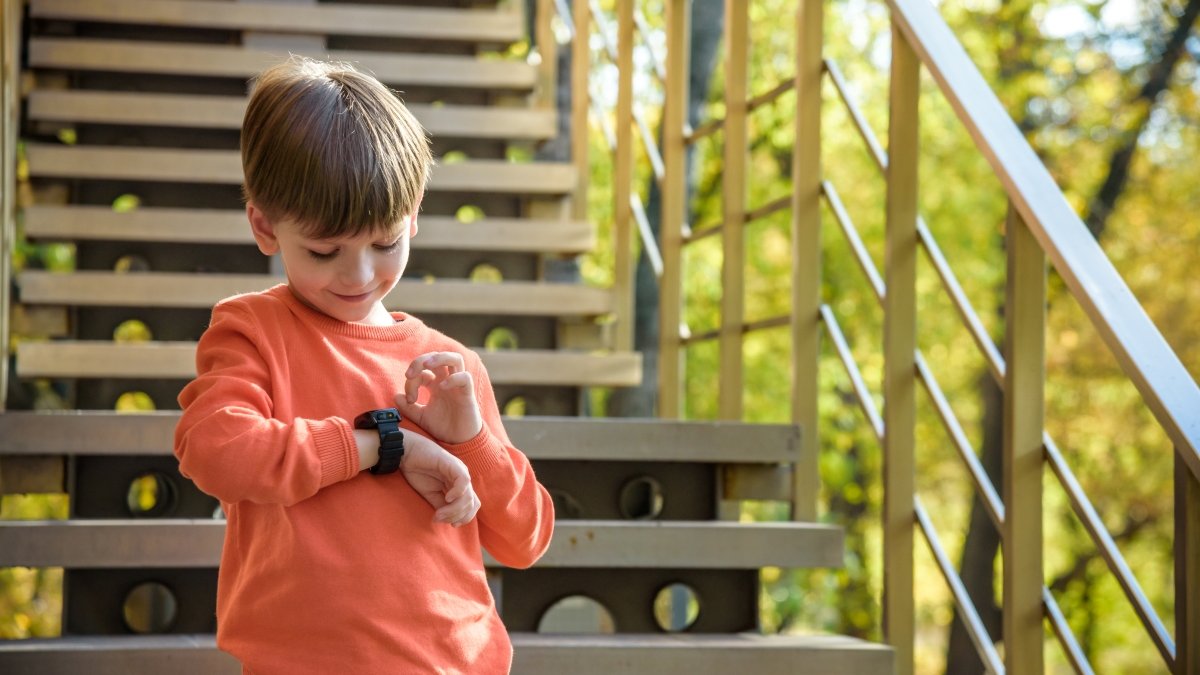 A cute boy looking at his smart watch