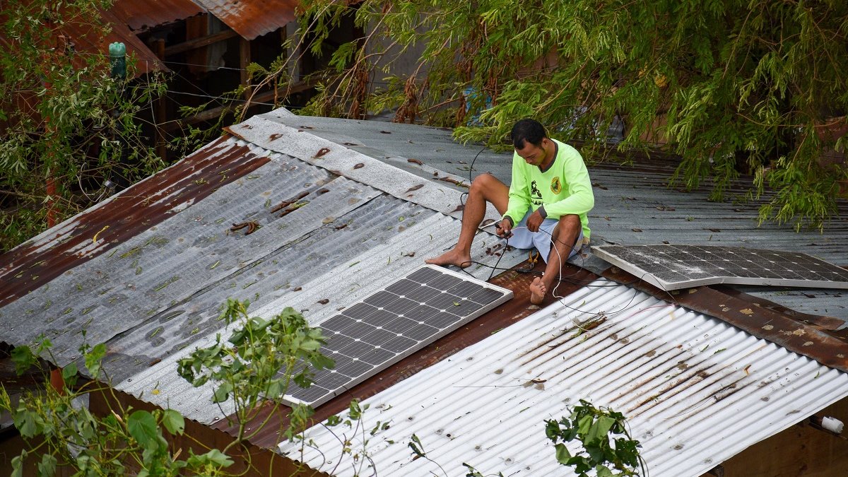 Filipino man setting up solar panels