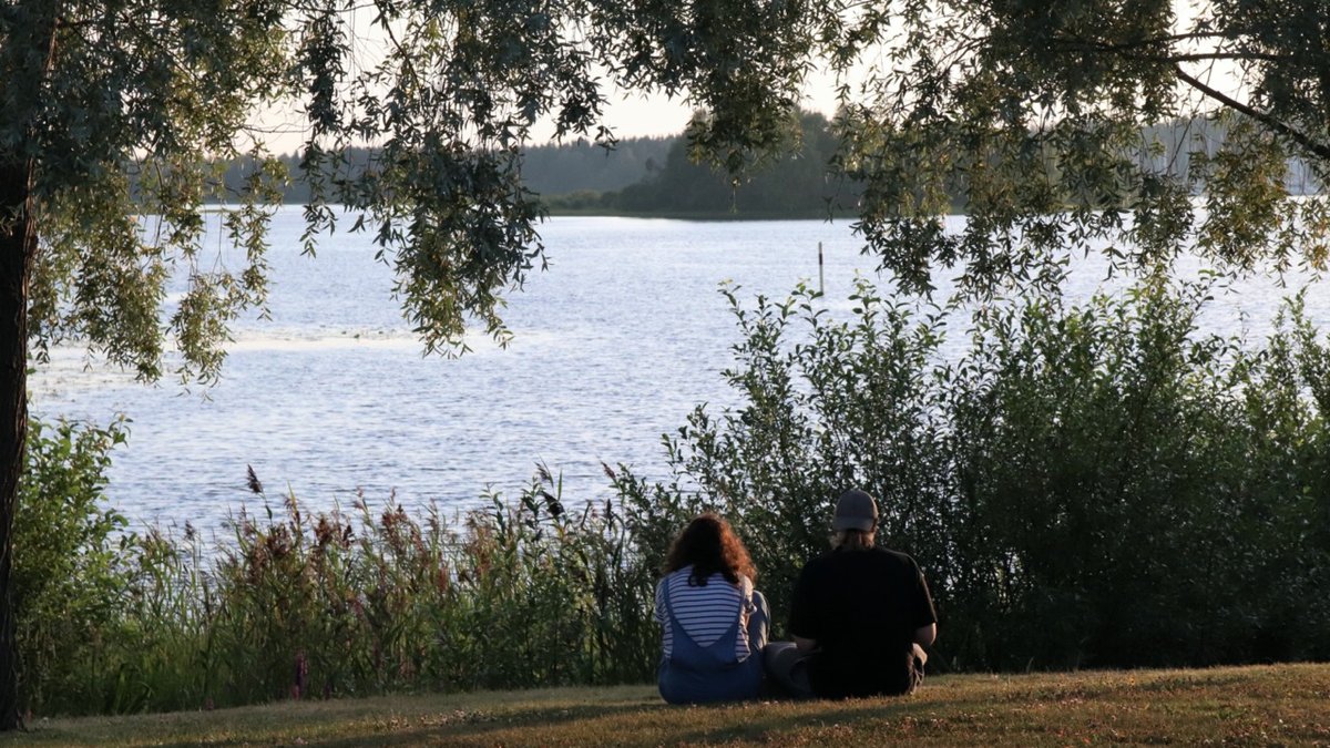 Para rozmawiająca nad brzegiem jeziora