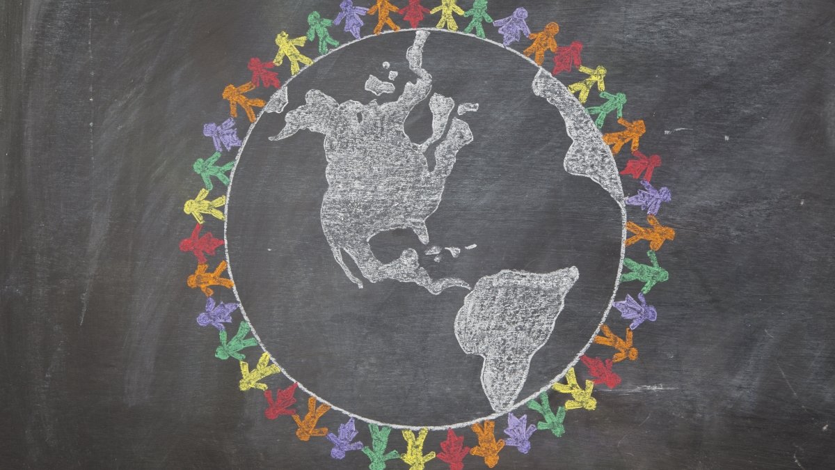 A hand drawn chalkboard shows multi-ratial people holding hands around the world