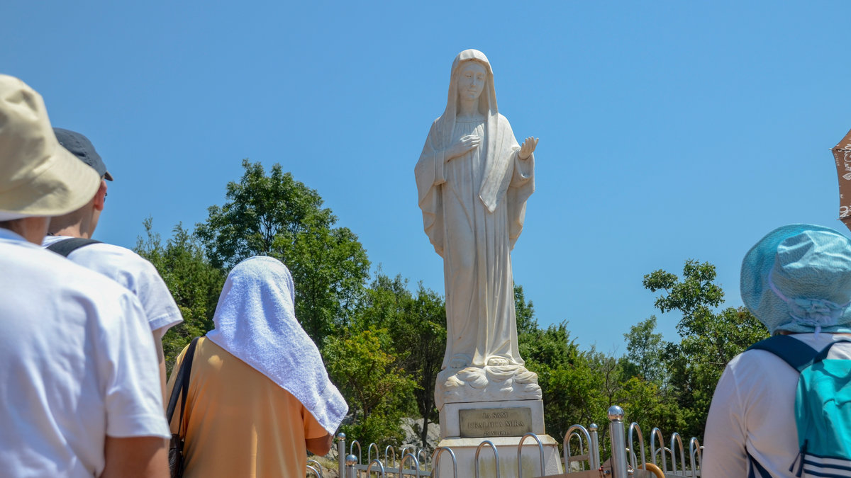 Pilgrims-in-Medjugorje-Statue-of-Virgin-Mary-AMMBS1724-shutterstock_2222277153-e1726742763344.jpg