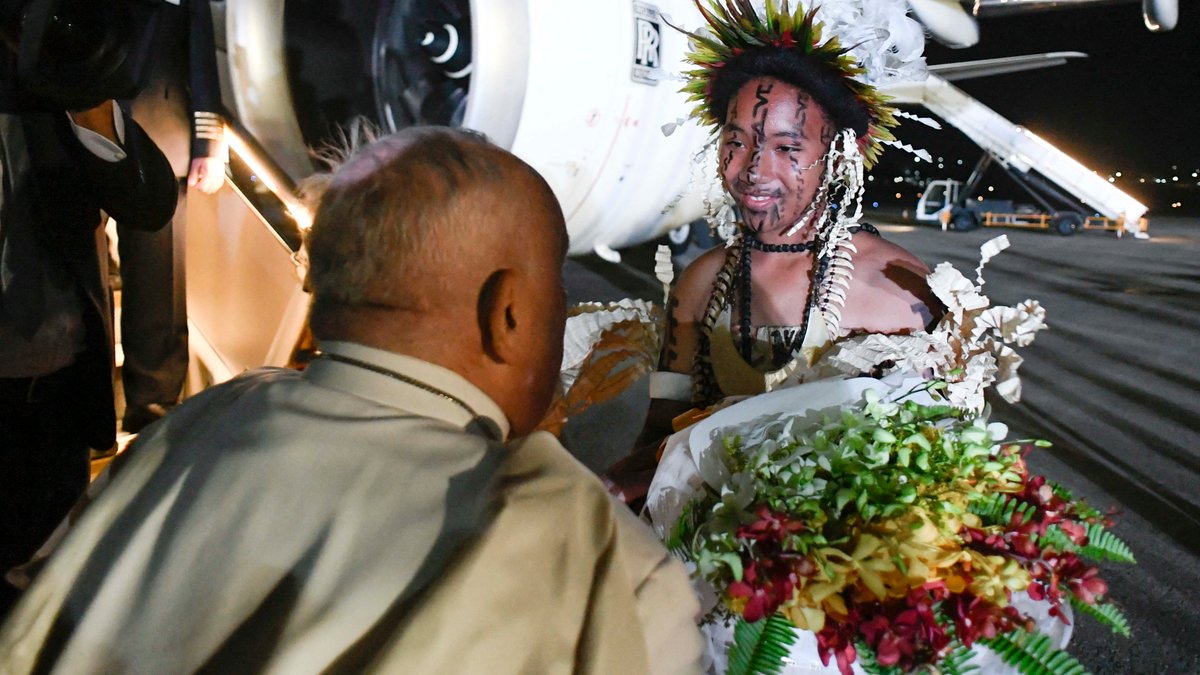 Pope Francis is greeted upon arrival at the Port Moresby International airport.