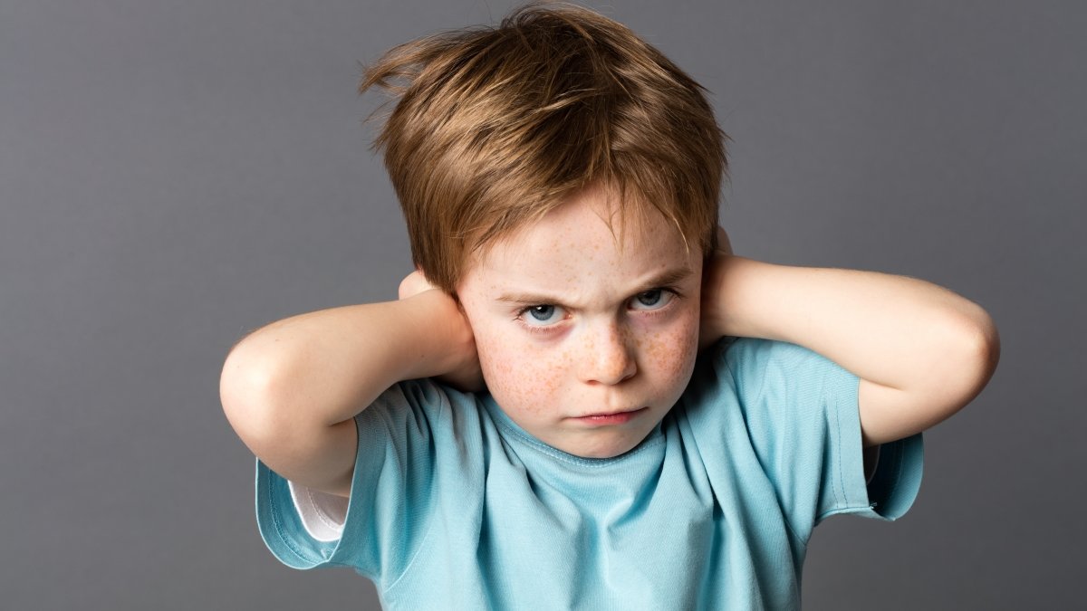 stubborn little kid with red hair, freckles and an attitude ignoring parents scolding