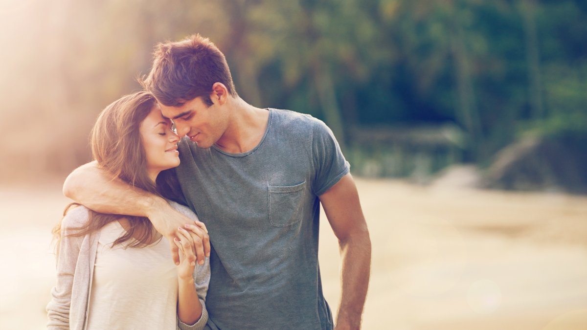Couple, holding hands and hug on beach date in outdoors, love and bonding in relationship on vacation