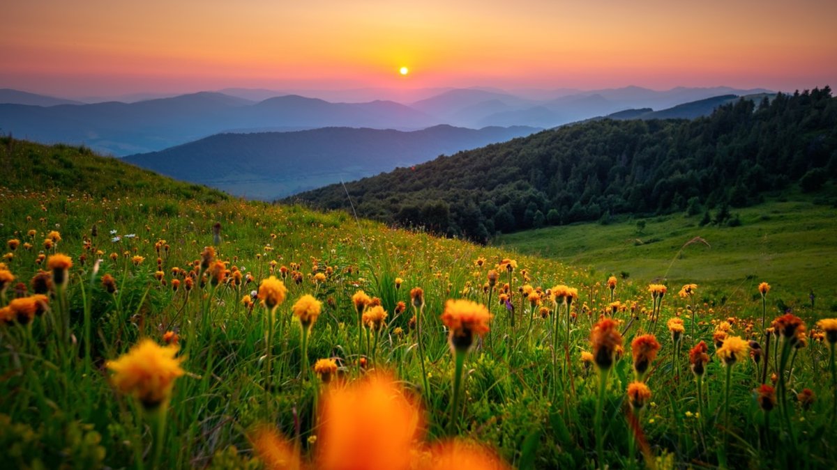 The sun sets behind the mountain ranges