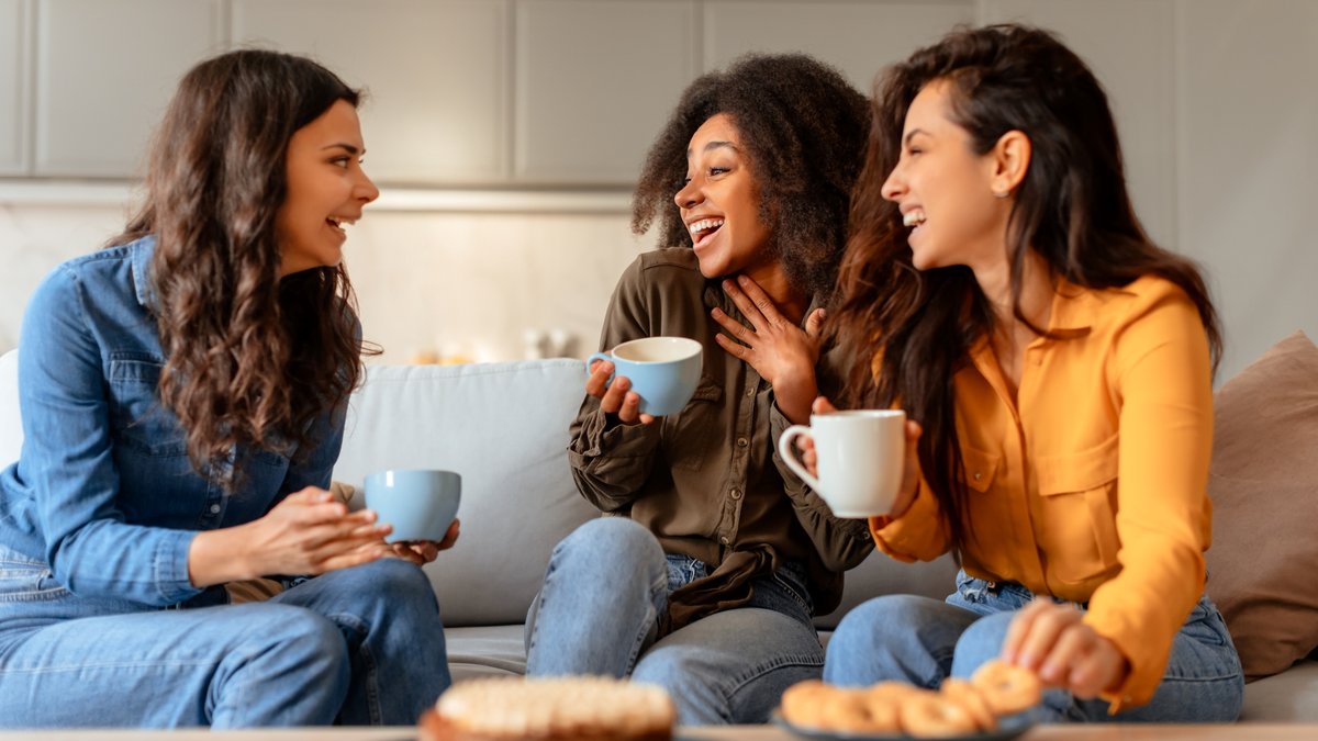 3 women laughing and conversing