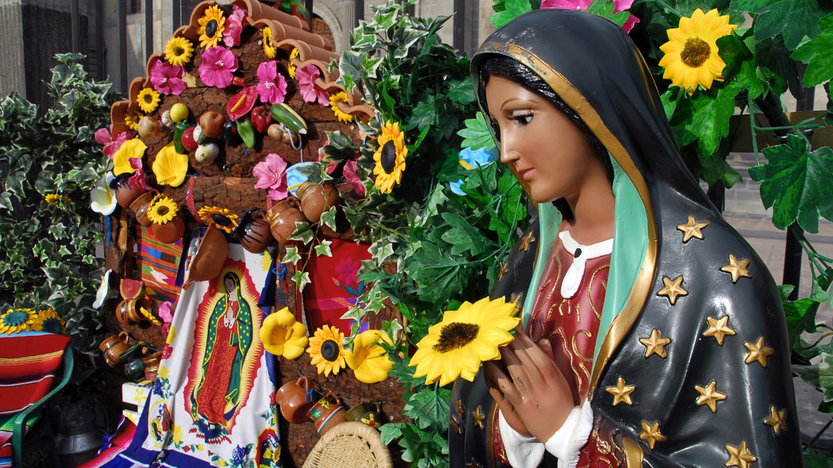 Statue of Our Lady of Guadalupe amid flowers