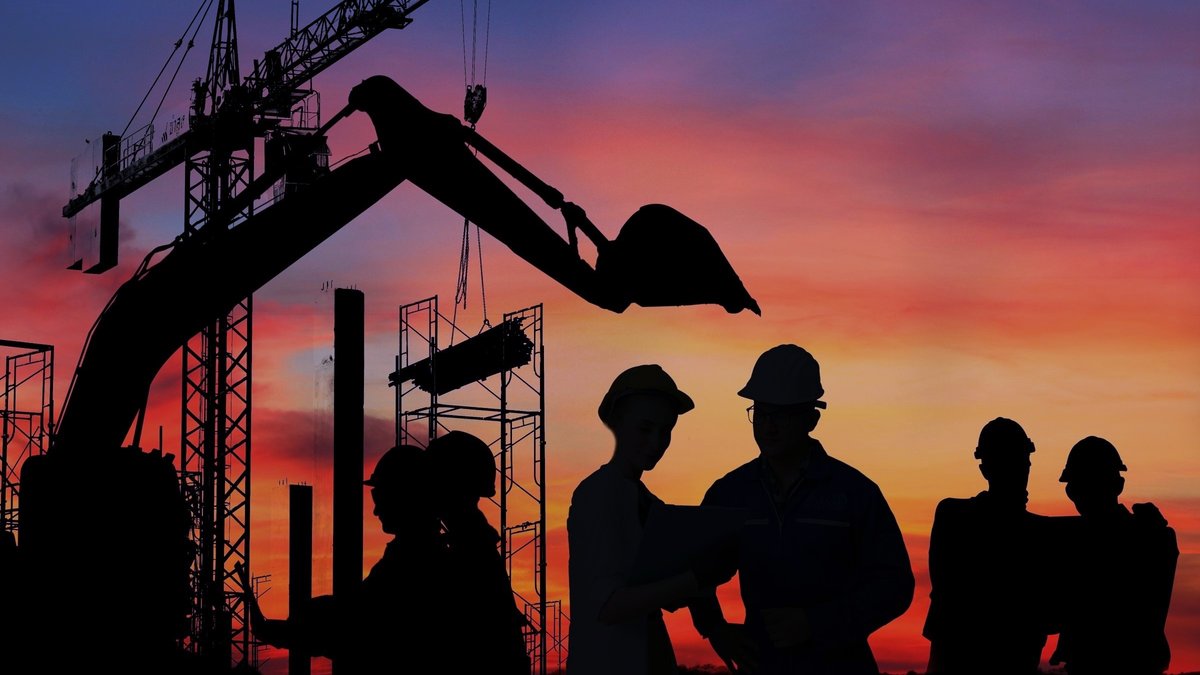 construction workers on site in silhouette dawn