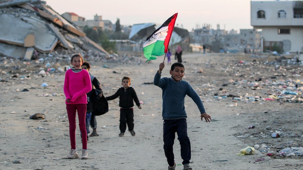 Children in Gaza run with Palestinian flag